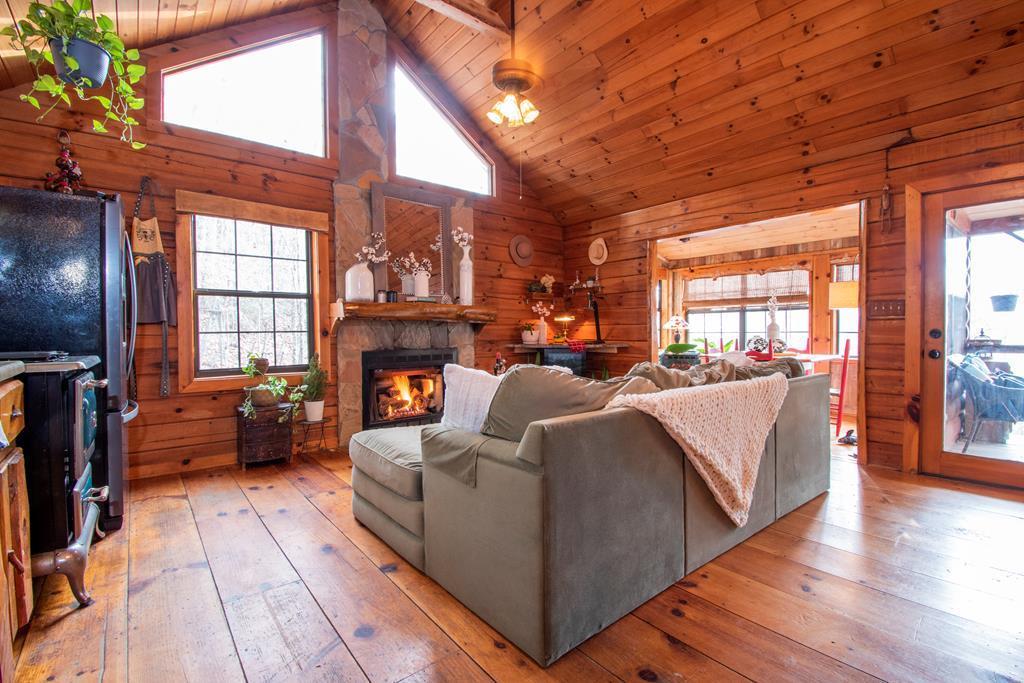 Take me back to the good ol days! True log cabin on over 2 unrestricted acres reminds you of simpler times, yet w/ all the modern comforts! Enjoy the mountain view sunsets from your front porch, cozy up by the fireplace in the great room, & cook your gravy & biscuits on the antique gas stove. This cabin has ALL THE COUNTRY CHARM. Main level has wood flooring throughout, tongue & groove cathedral ceilings & rock fireplace in the great room, pellet stove in the sunroom, open loft for additional sleeping/storage, bedroom & en suite full bathroom w/ jetted soaker tub. Basement level has a large mudroom/laundry, bedroom, & full bathroom. Multi level porches, storage building,& high speed internet