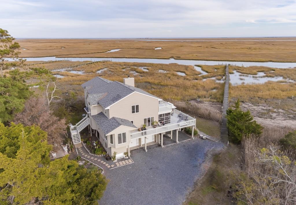 Beautiful waterfront home with expansive views of the Creek and Marshes.  Take in the gorgeous view from the open great room which has vaulted ceiling and a large fireplace.  Wake up to the breathtaking sunrise everyday.  Water views from almost every room.  Relax on the deck or screened in porch with a good book while admiring the view.  Home has hurricane rated roof, new HVAC (2018), tankless water heater, new garage doors (2017), generator and stainless steel appliances.  Walk down the dock hop in your boat and head out to the barrier islands. Stunning view!   A must see!