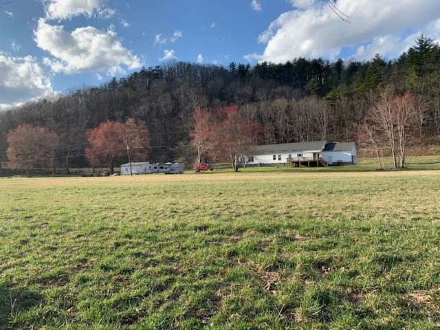 Great House! Flat Fields With Barn! Bold Creek! Joins National Forest! This property is conveniently located near the Bastian exit for quick access to Interstate 77 but is far enough that the interstate can't been seen or heard. The land is flat in the front with wolf creek running through it. There is a second home on the property at the back of the fields that could be fixed as a guest house or would make a great work shop. Several trails exists on the wooded portion which borders a larger National Forest tract. A new barn and fencing has been installed. The home has had some new flooring and paint. It is very spacious and is all on one level with a 2 car  attached garage.