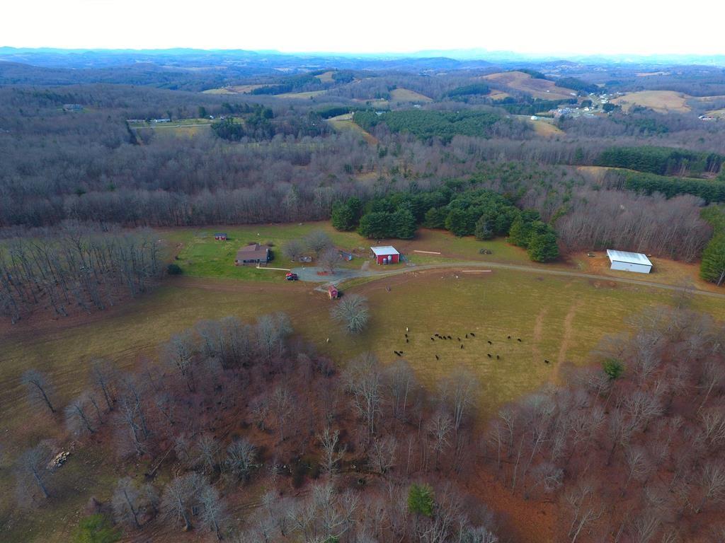 Stunning 92+/- acre working cattle farm located just off the blue Ridge Parkway in Southwest Virginia! This beautiful farm offers a 4 bedroom 3 bath cedar sided home that is recently renovated and comes completely furnished. Beautiful hardwood flooring, eat in kitchen with major appliances convey, large open living/dining combination that boasts rustic beamed accents and stone wood burning fireplace. All 3 bathrooms have been updated with new vanities, tile showers and flooring.  Partially finished basement, two covered porches and open deck, multiple sheds and timber/paver carport.  There are 2-large barns and one shed barn at the back of the property. Land is a mixture of woods and approximately 60 acres of open pasture with outstanding views, fenced and cross fenced with high tensile wire, an abundance of water with three streams and five water troughs for your livestock. Plenty of wildlife, Great location with privacy and within minutes to Galax, New River and The New River Trail.
