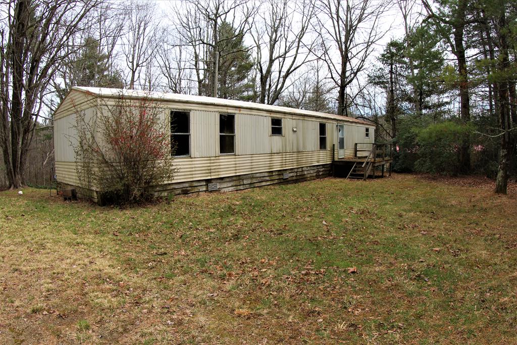 Single wide Fixer-upper (14' x 68') with 1.69 ac located in Patrick County, VA (221 Ballard Rd, Meadows of Dan, VA 24120). Main floor: Kitchen, Dining Room, Master Bedroom, Master Bath, Living Room, 2 more bedrooms and Full Bath. Fronts on state paved road (Ballard Road). Gravel Driveway. Front porch. 1 car garage/workshop. Metal Building (26' x 28') with one garage door and a personnel door. Wood siding storage building (26' x 15'). Land is level to slightly rolling. 1/4 ac pond. Sold As IS - no warranties.  5 minutes to Meadows of Dan, VA and the Blue Ridge Parkway. 20minutes to Stuart, VA. 20 minutes to Floyd, VA. 30 minutes to Hillsville, VA and Interstate I-77. 45 minutes to Mt. Airy, NC.